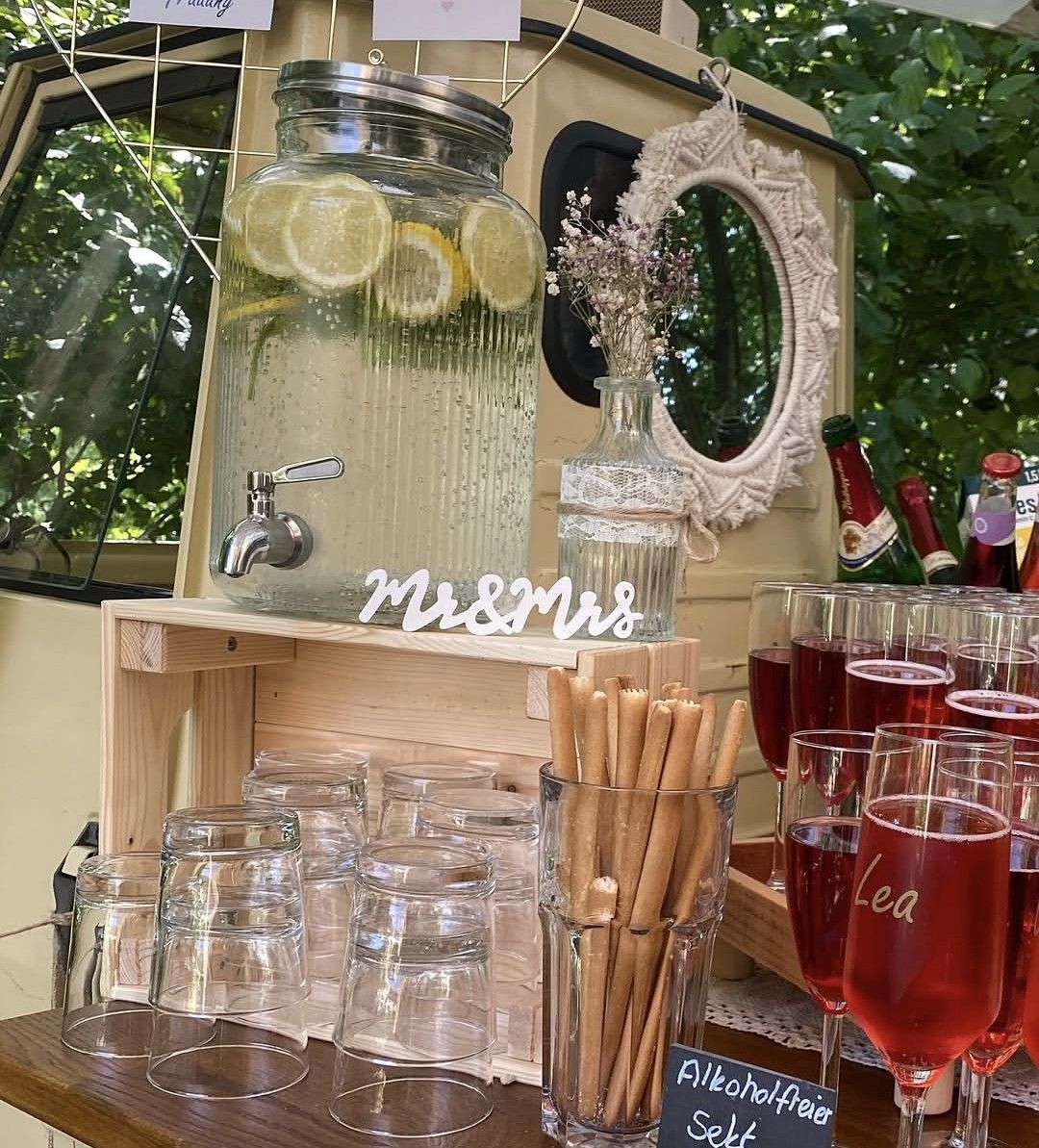 Liebevolle Details an der Ape-Bar: Zitronenwasser im Getränkespender, Mr-und-Mrs-Schriftzug und alkoholfreier Sekt